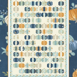 May include: A fabric quilt with a pumpkin design. The quilt displays rows of stylised pumpkins in shades of blue, orange, and cream, set against a navy blue background. The text "Pumpkin Kisses" and "by Coach House Designs" are visible.