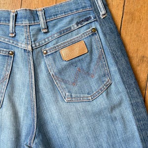 Pu&ograve; includere: Jeans di denim blu chiaro con il logo Wrangler sulla tasca posteriore. I jeans hanno un classico design a cinque tasche con rivetti e cuciture in rame. I jeans sono realizzati in un resistente tessuto denim.