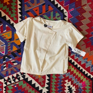 Blusa origami de mezcla de algodón neutro, años 80 (talla grande). Stock remanente.