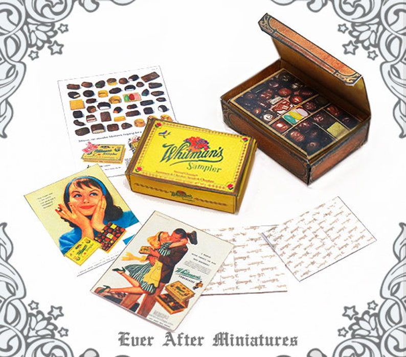 May include: A miniature dollhouse scene featuring a Whitman's Sampler chocolate box, a vintage advertisement for Whitman's chocolates, and a miniature box of chocolates. The scene is set on a white background with a decorative border.