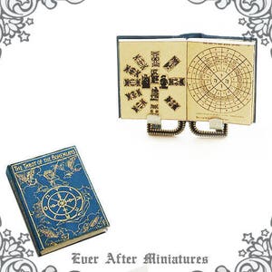 May include: A miniature book titled "The Tarot of the Bohemians" with a blue cover and gold accents. The book is open to reveal a detailed illustration of a tarot card. The book is sitting on a white surface.