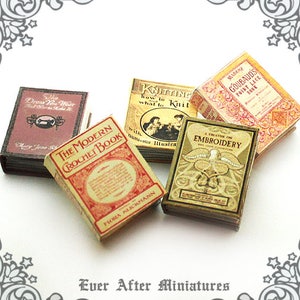 May include: A collection of miniature vintage books with titles like "The Dress You Wear", "The Modern Crochet Book", "Knitting", "A Treatise on Embroidery", and "Madame Goubaud's Point Lace Book".