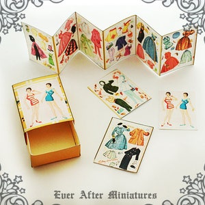 May include: A miniature paper doll set with a variety of outfits and accessories. The dolls are dressed in vintage-style clothing and have a charming, whimsical look. The set comes in a small box with a drawer for storage.