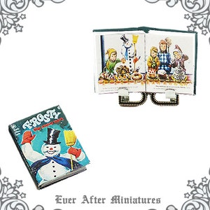 May include: A vintage book titled "Frosty the Snow Man" with a colorful illustration of Frosty on the cover. The book is next to a miniature open book with a green cover and illustrations of children making a snowman.