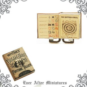 May include: A miniature book titled "The Witches Dream Book Fortune Teller" with a vintage design. The book is open to reveal a page with a list of items. The book is sitting on a miniature stand with a book titled "The Egyptian Circle; Ancient Wheel of Fortune".