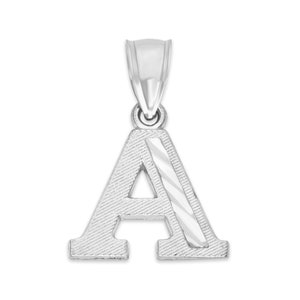 Könnte beinhalten: Silberner Anhänger in Form des Buchstabens A. Der Buchstabe hat eine strukturierte Oberfläche und eine diagonale Linie in der Mitte.