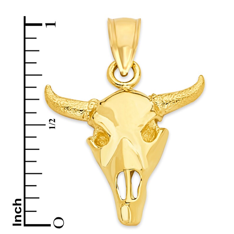 May include: A gold-tone bull skull pendant charm. The pendant is about 1 inch tall and features a detailed design of a bull's skull with horns.