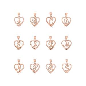 May include: Rose gold heart-shaped pendants, each featuring a different letter of the alphabet. The letters are stylized and set within a textured heart frame. The pendants are displayed against a white background.