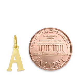 May include: Gold-toned letter A charm pendant, approximately the size of a US penny.