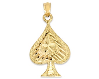 May include: A gold-colored pendant in the shape of a spade, featuring a textured surface and a star design in the center. The pendant has a loop at the top for a chain.