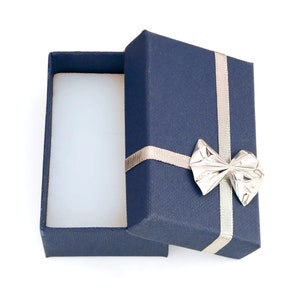May include: An open blue gift box with a silver bow. The box is empty and ready to be filled with a special gift.