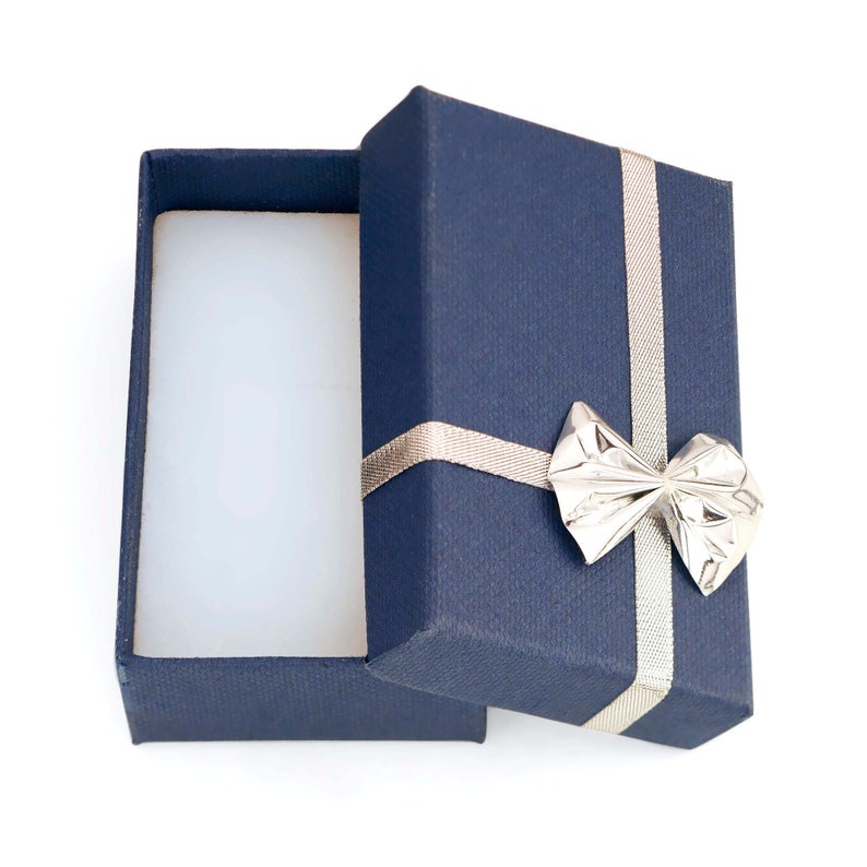 May include: An open blue gift box with a silver bow. The box is empty and ready to be filled with a special gift.