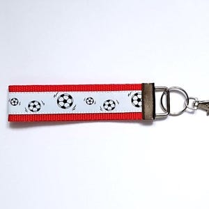Football keychain pocket charm red, black, white.