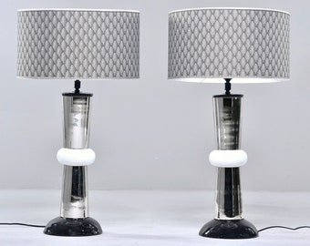 Puede incluir: Dos lámparas de mesa plateadas con bases negras y detalles blancos. Cada lámpara tiene una pantalla de lámpara con estampado gris y blanco.