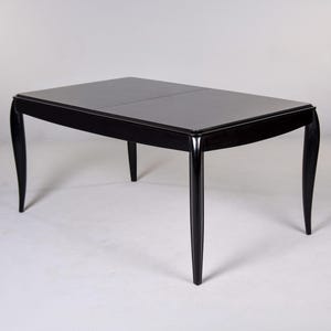 May include: A black rectangular dining table with a glossy finish. The table has four curved legs and a rectangular top. The table is approximately 152 cm long and 91 cm wide.