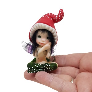 Seated forest fairy, small fairy, decorative figurine, elf, elf, fantasy, green-eyed fairy, fairy with red cap, cold porcelain,