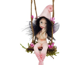 Forest fairy on swing. Decorative porcelain cold porcelain fairy figure elf, miniature fairy elf, fairy garden, pink color