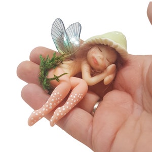 Forest fairy sleeping. Decorative fairy figure, magical gift, elf, lying fairy elf, fantasy object, fairy in pastel tones