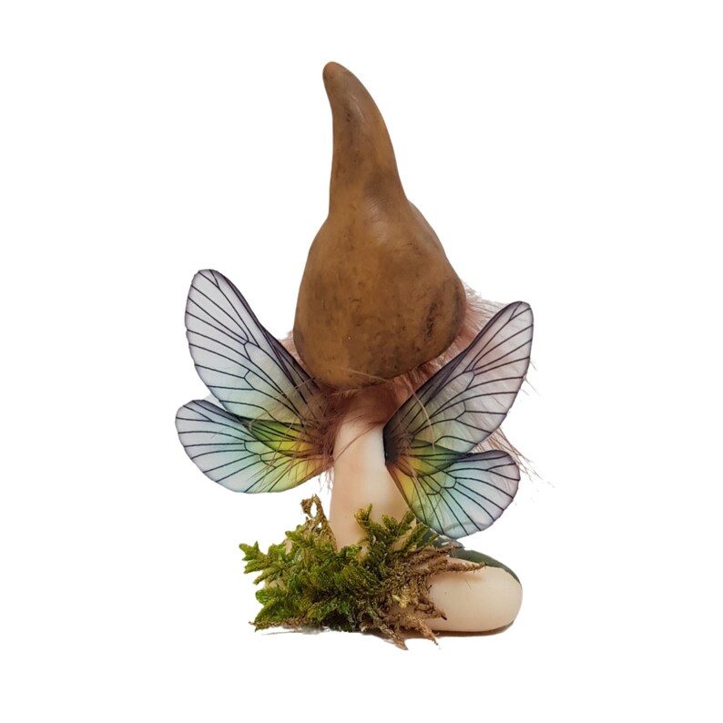 May include: A small fairy figurine with iridescent wings, a brown mushroom cap, and a green mossy base.