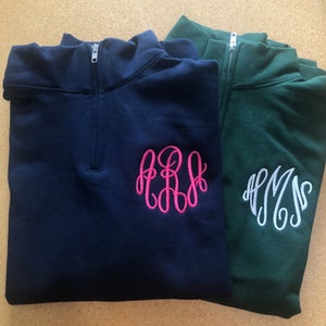 May include: Two quarter-zip sweatshirts, one navy blue with a pink monogram "PRS" and one green with a white monogram "AMS".