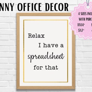 Può includere: Una stampa incorniciata con la scritta "Relax I have a spreadsheet for that" in nero. La stampa ha un bordo dorato e una cornice marrone chiaro. Le parole "FUNNY OFFICE DECOR" sono in alto. Un'etichetta rosa indica le dimensioni incluse.