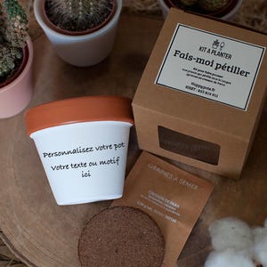Peut inclure: Un pot de fleurs blanc avec un bord en terre cuite et le texte "Personnalisez votre pot Votre texte ou motif ici". Une boîte en carton marron avec l'inscription "KIT A PLANTER Fais-moi pétiller" est à côté.