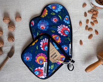 Puede incluir: Un juego de manopla y agarradera azul marino con un estampado floral en rosa, amarillo, azul y blanco. El juego incluye una etiqueta con texto. También hay nueces, almendras y un rodillo.