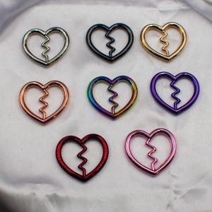 以下が含まれることがあります： シルバー、ゴールド、ローズゴールド、ブラック、パープル、レッド、ピンクなど、さまざまなカラーの壊れたハートチャームの詰め合わせ。