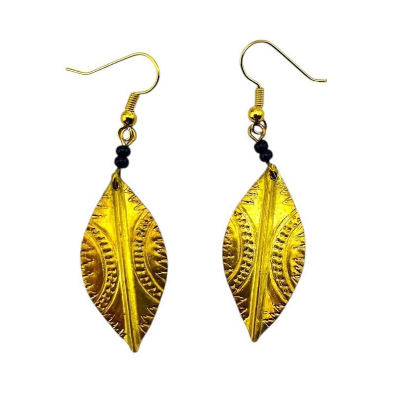 May include: A pair of gold-colored leaf-shaped earrings. Each earring features a detailed embossed design and is suspended from a gold-tone hook with small black beads.