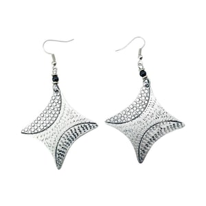 May include: A pair of silver earrings with a geometric design. The earrings are made of metal and have a textured surface.