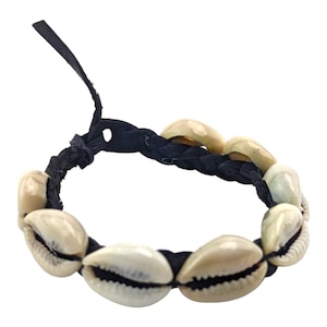 May include: A handcrafted bracelet featuring a series of cream-colored seashells strung on a dark blue braided cord. The bracelet has a loop and tie closure. The shells are smooth and have natural markings.