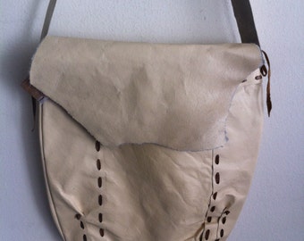 Beige handgemaakte leren tas, grote schoudertas op een lange band.