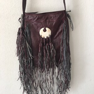 Handgemachte Handtasche aus Naturleder - Farbe Burgund; mit Fransen; mit dekorativen Elementen;  Größe klein.