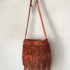 Women&#39;s orange suede  handmade handbag ;natural  suede; bag on long handle with fringe and original pockets ;size small ,made in the USA.