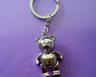 Llaveros de osito de peluche plateados con brazos y piernas articulados.