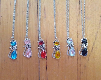 Bonitos collares con colgantes de gatos plateados y piedras de colores.