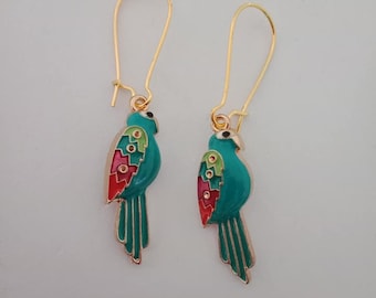 May include: A pair of parrot-shaped earrings. Each earring features a teal body with red, pink, and yellow accents on the wing and tail. The earrings have gold-colored, long hook closures.