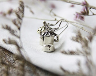 May include: A pair of silver earrings shaped like miniature coffee pots. The earrings are delicate and have a vintage feel.