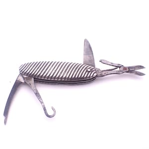 Puede incluir: Una multiherramienta vintage plateada con mango acanalado. Incluye una hoja de cuchillo, tijeras y un gancho. Las herramientas abiertas se muestran sobre un fondo blanco, mostrando sus diversas funciones. Una herramienta de bolsillo clásica.