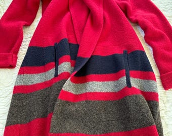 May include: A red, grey, and navy blue striped cardigan with a large hood. The cardigan is open in the front and has a relaxed fit.