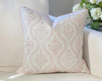 May include: A square throw pillow featuring a cream-colored fabric with a repeating dusty pink botanical pattern. The design consists of vertical ogee-shaped panels filled with intricate floral and leaf motifs, finished with matching pink piping.