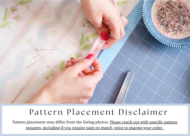 May include: A close-up of hands working with fabric and sewing supplies. The hands are holding a pink ribbon, with a pair of scissors and a blue and white bowl of pins nearby. The fabric has a floral pattern. The image includes the text "Pattern Placement Disclaimer".