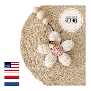 May include: A crocheted flower with a bee in the center, set on a woven mat. The flower has off-white petals, a pink center, and a small bee. The text "CROCHET PATTERN HAAKPATROON" is in a circle.