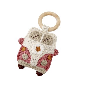 May include: A crocheted pink and white toy van with a wooden ring attached. The van has a flower on the front and brown details.
