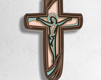 May include: A layered wooden cross depicting Jesus Christ. The cross has a brown outer frame, with light brown, teal, and peach-coloured layers. The image includes the text "SVG - EPS - DWG - DXF - AI" at the bottom.