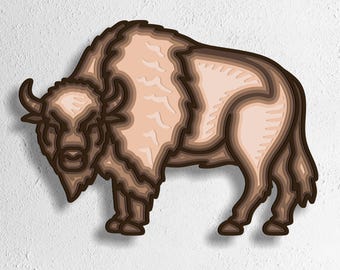 May include: A layered paper art piece of a bison in shades of brown and tan. The bison is depicted in a side profile, with detailed fur and horns. The image includes the text "SVG - EPS - DWG - DXF - AI" at the bottom.