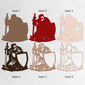 K&ouml;nnte beinhalten: Sechs geschichtete Ausschnitte eines Ritters in R&uuml;stung, jeweils in einer anderen Farbe. Der Ritter kniet und h&auml;lt ein Schwert und einen Schild. Die Schichten umfassen Braun, Rot, Hellrosa, Schwarz, Beige und Hellbraun. Der Schild auf Schicht 3 hat ein Kreuz.