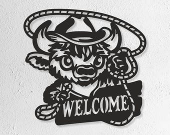 May include: Black metal wall art depicting a cartoon bull wearing a cowboy hat and holding a lasso. The word "WELCOME" is displayed below the bull. The art is designed with a cutout style.