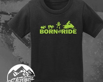 May include: Black t-shirt with a green graphic of a child growing up and riding a snowmobile. The text "BORN TO RIDE" is below the graphic.