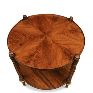 May include: A round, two-tiered wooden table with a starburst pattern on the top. The table has a dark brown finish and gold accents on the legs.